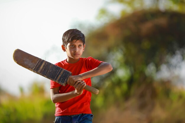 Enfant indien rural jouant au cricket