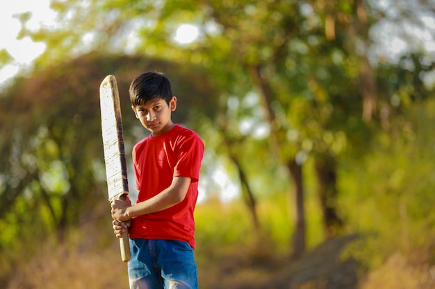 Enfant indien rural jouant au cricket