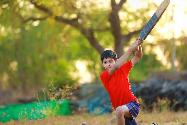 Enfant indien rural jouant au cricket