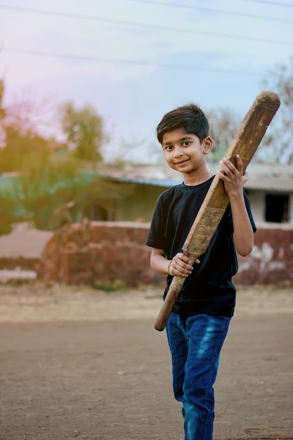 Enfant indien rural jouant au cricket