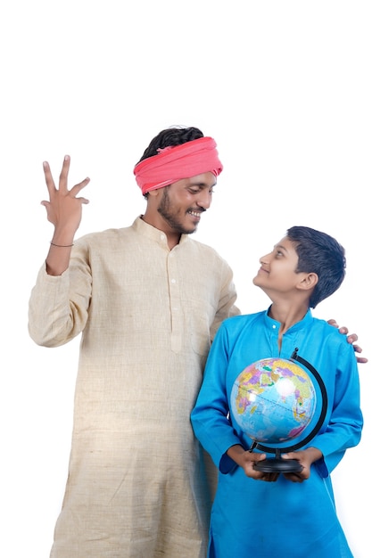 Enfant indien tenant un globe terrestre à la main et son père donnant des informations.