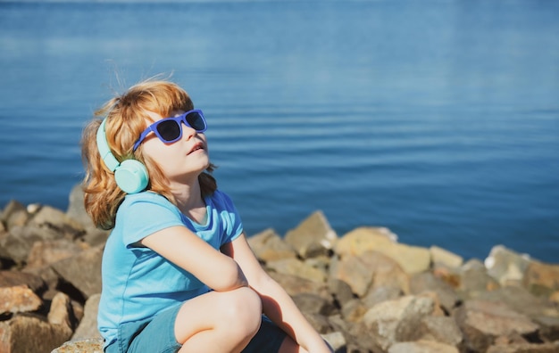 Enfant insouciant Enfant dans les écouteurs en plein air Écouter le concept de musique