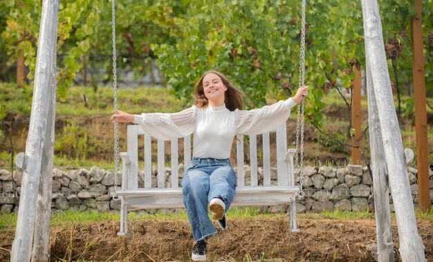 Enfant insouciant se balançant à l'extérieur. adolescente s'amusant sur l'aire de jeux. bonheur d'enfance. détendez-vous dans le parc. activité estivale. Émotions positives. enfant heureux sur la balançoire.