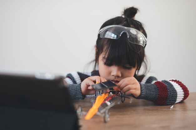 Enfant inventif construisant des voitures de robot à la maison