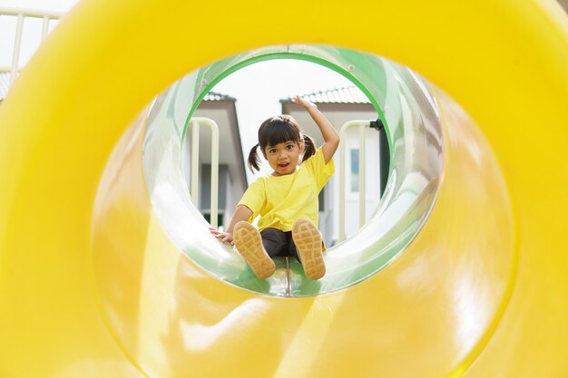 Enfant jouant sur une aire de jeux extérieure. Les enfants jouent dans la cour de l'école ou de la maternelle.