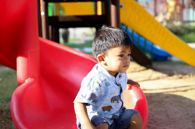 Enfant jouant sur une aire de jeux extérieure.