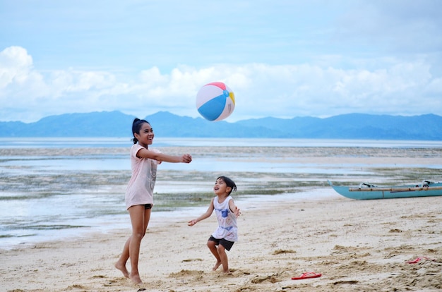 Enfant jouant au ballon sur la plage