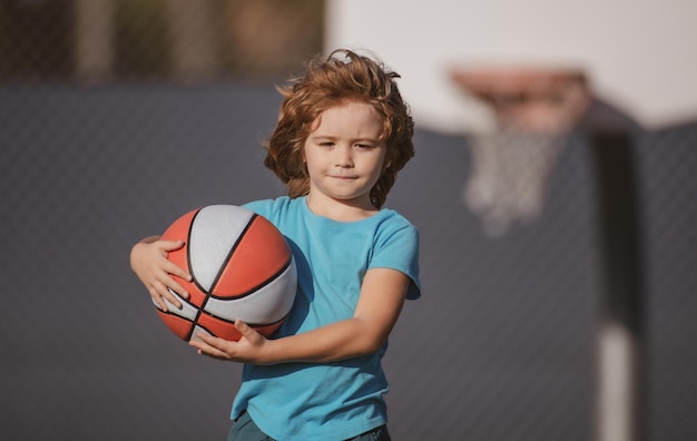 Enfant jouant au basket avec un ballon de basket enfant posant avec un ballon de basket