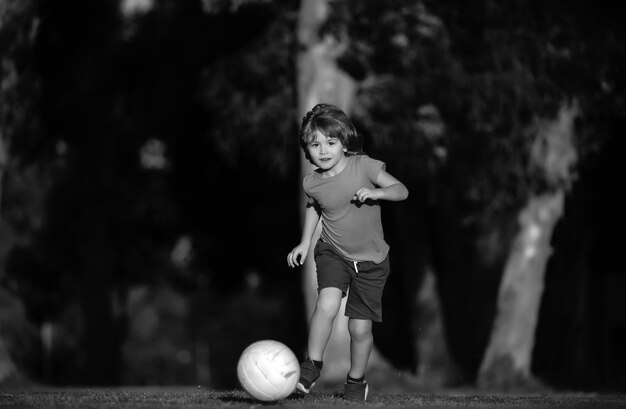 Un enfant jouant au football sur un terrain de football, un enfant jouer au football, un joueur de football dans un parc.