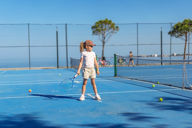 Enfant jouant au tennis sur un court extérieur