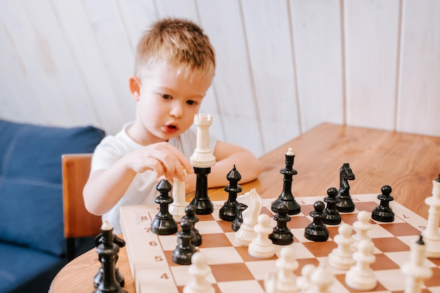 Enfant jouant aux échecs à la maison à la table