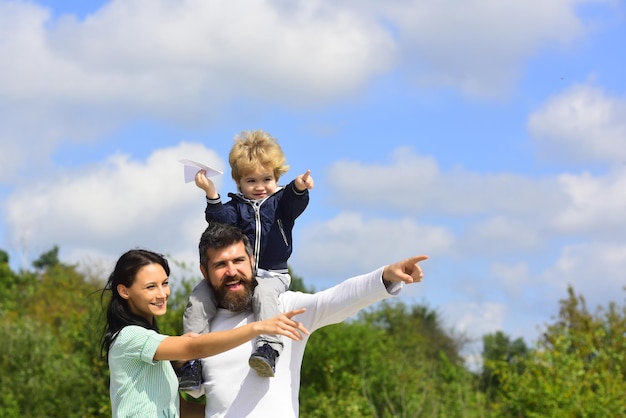 Enfant jouant avec un avion jouet et rêvant d'un futur concept de rêves et de voyages Portrait de famille heureux s'amusant avec un avion en papier jouet Père mère et fils enfant