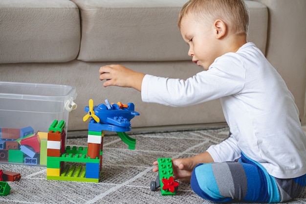 Enfant jouant avec des blocs de jouets assis sur le sol