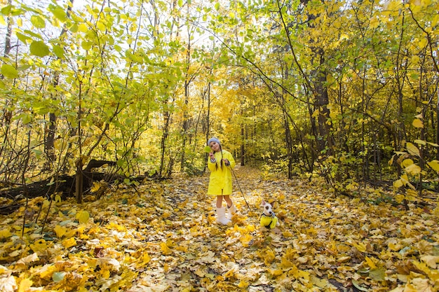 Enfant jouant dans le parc de l'automne avec un jack russell terrier