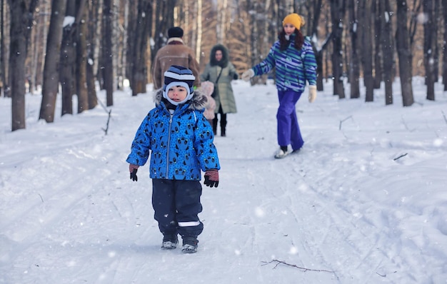 Enfant jouant dans un parc d'hiver et s'amuser en famille