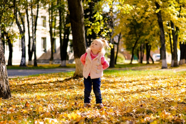 Enfant jouant dans le parc Petite fille marchant et jouant dans le parc en automne