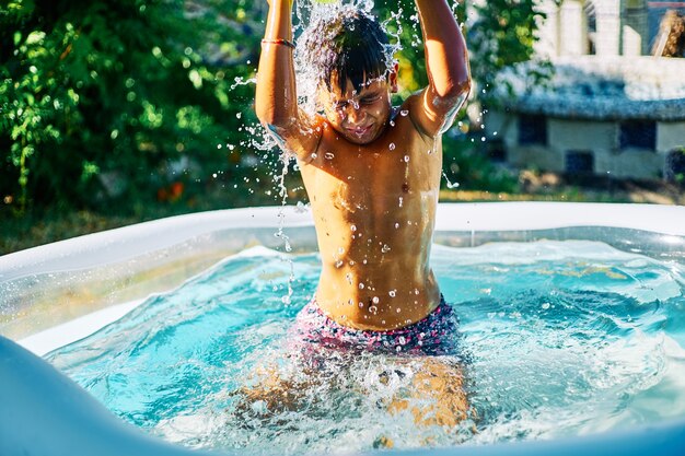 Enfant jouant dans une piscine gonflable dans le jardin familial