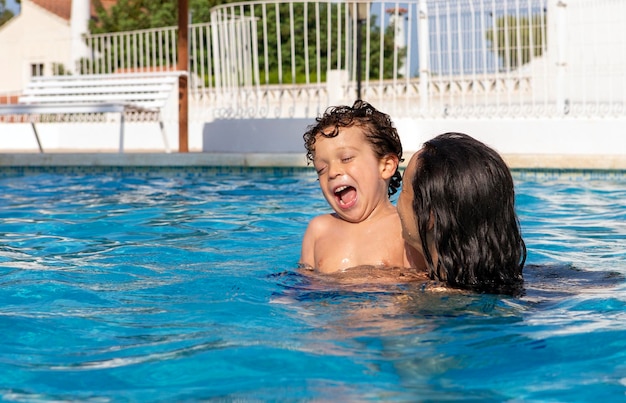 Enfant jouant dans la piscine avec sa mère