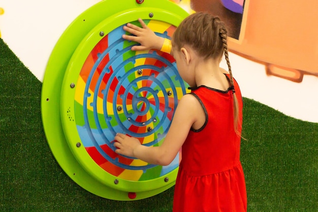 Enfant jouant avec du labirint en bois dans un centre de jeux à l'intérieur