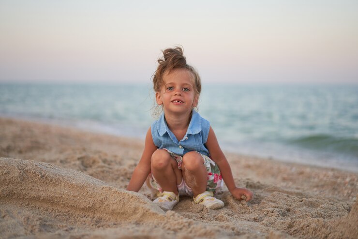 Photo enfant jouant avec du sable sur la plage