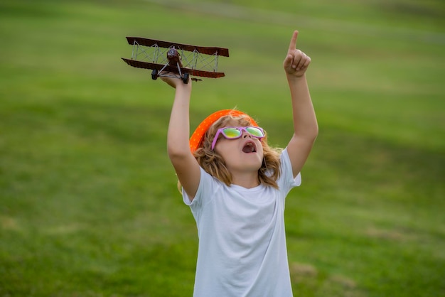 Enfant jouant Enfant s'amusant avec un avion jouet dans le champ Enfant pilote aviateur avec des rêves d'avion