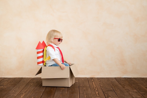 Enfant jouant avec une fusée en papier