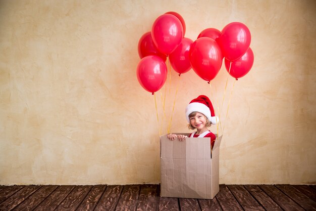 Enfant jouant à la maison. Cadeau de Noël. Concept de vacances de Noël