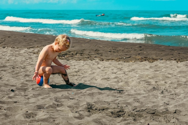 Photo un enfant jouant sur la plage.