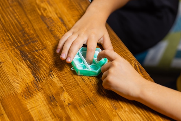 Enfant jouant avec pop itpressant les bulles avec son doigt viewnouveau jouet antistress pour enfant...