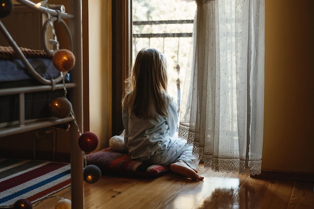 Enfant jouant près de la fenêtre à la maison onirique