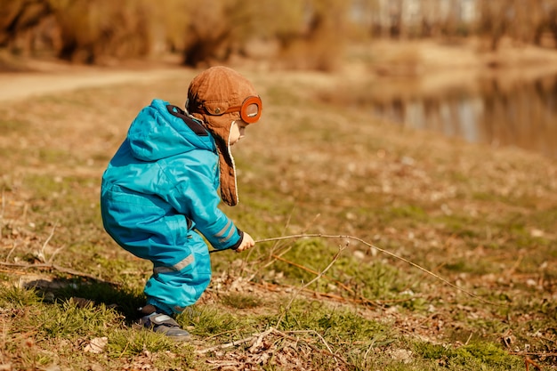 Enfant jouant sur la rive de la rivière dans l'air. Mode de vie actif