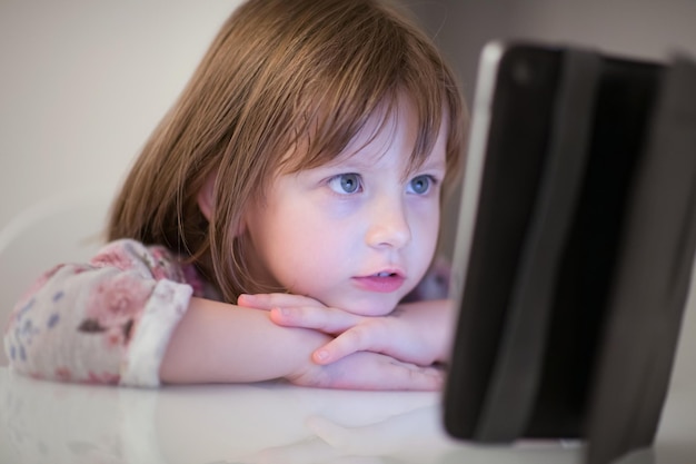 enfant jouant avec une tablette numérique à la maison