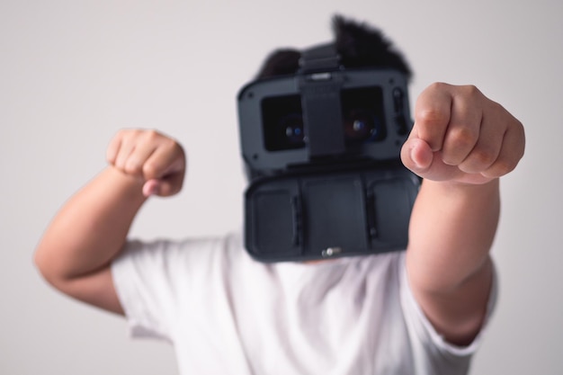 L'enfant joue à la boîte VR sans smartphone Poses de combat isolées sur fond blanc et gris Cette photo est centrée sur les mains