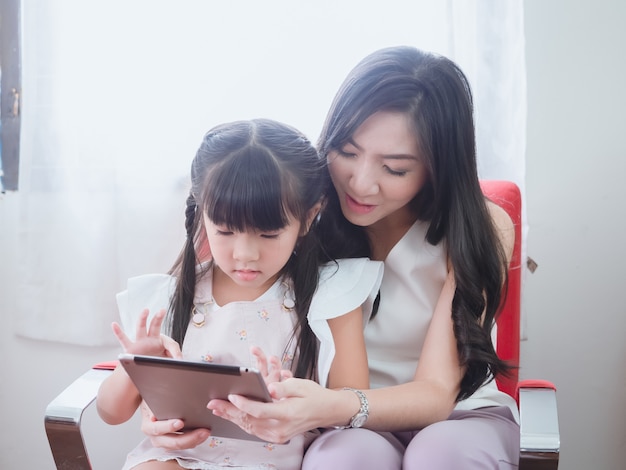 L'enfant joue sur une chaise avec sa mère