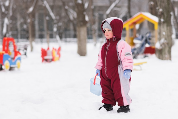 Enfant joue dans la cour de récréation en hiver