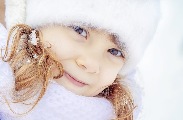 Un enfant joue dans la neige en hiver. Mise au point sélective.