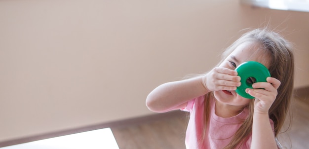 L'enfant Joue Avec Les Détails De La Pyramide. Fille Regarde à Travers Le Trou De La Roue. Concept De Développement Des Habiletés Motrices, Jeux éducatifs, Enfance, Journée Des Enfants, Jardin D'enfants, Copyspace En Résidence Surveillée