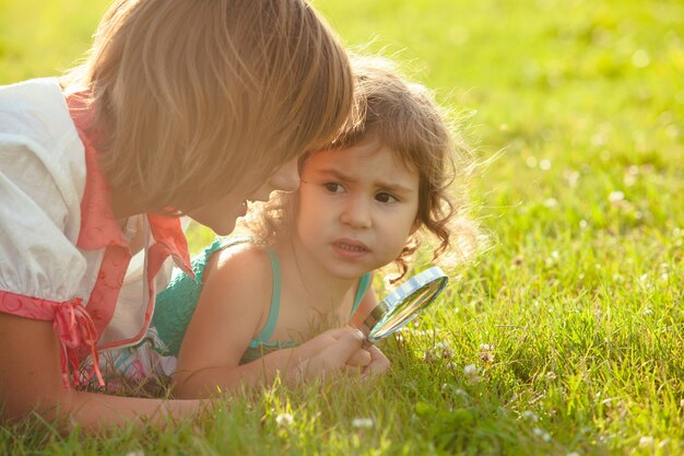 L'enfant joue avec la loupe dans le jardin