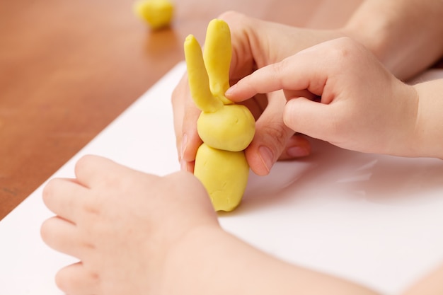 L'enfant joue avec de la pâte à modeler. Jeu fait main.