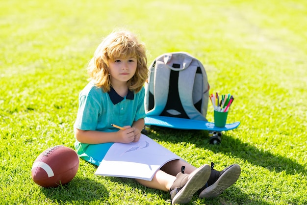 Enfant jouer et dessiner des devoirs d'art artisanal garçon de l'école dans le parc en plein air faire ses devoirs à l'école enfant ki