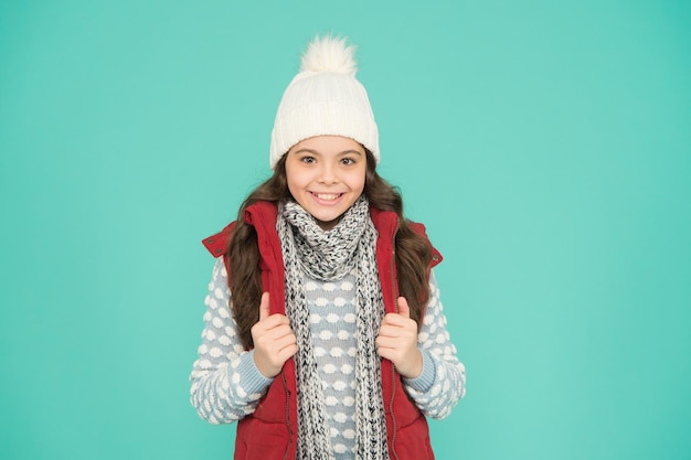 enfant joyeux dans des vêtements d'hiver chauds de chapeau tricoté, écharpe et pull sur la mode des vacances du nouvel an