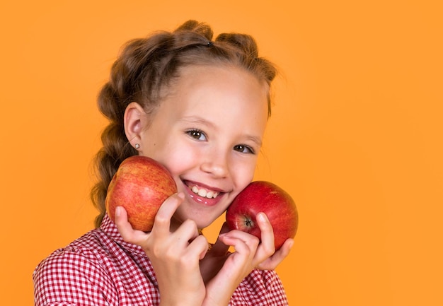 Un enfant joyeux mange des fruits pleins de vitamines un enfant souriant tient un régime végétarien aux pommes rouges