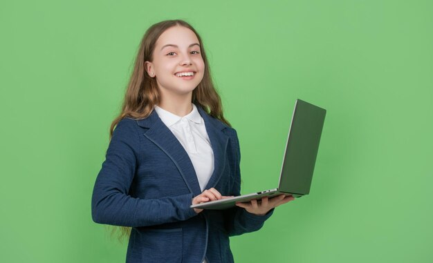 Enfant joyeux avec ordinateur sur fond vert