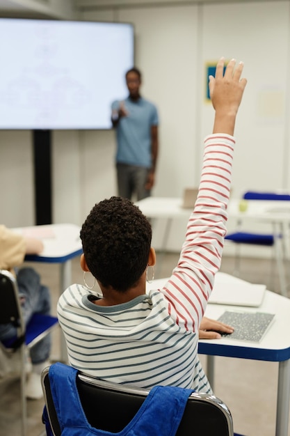 Enfant levant la main en classe