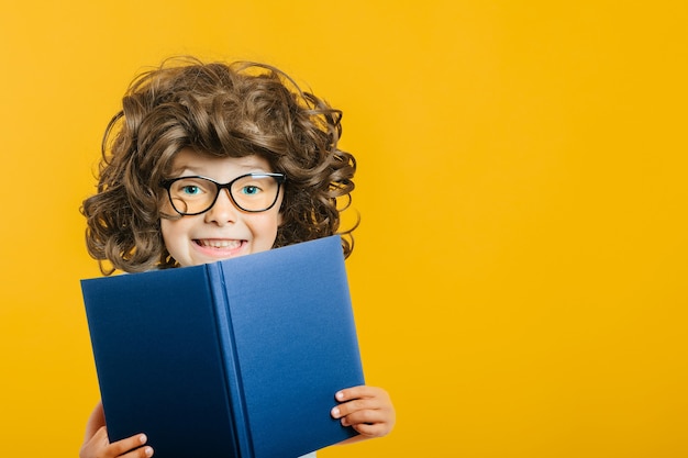 L'enfant lit un livre contre un mur lumineux