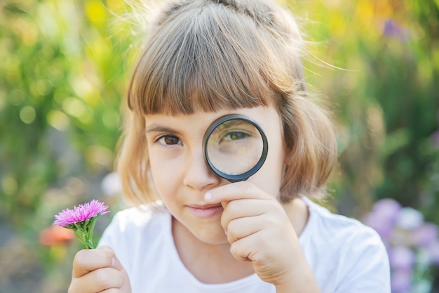 Enfant avec une loupe dans ses mains.