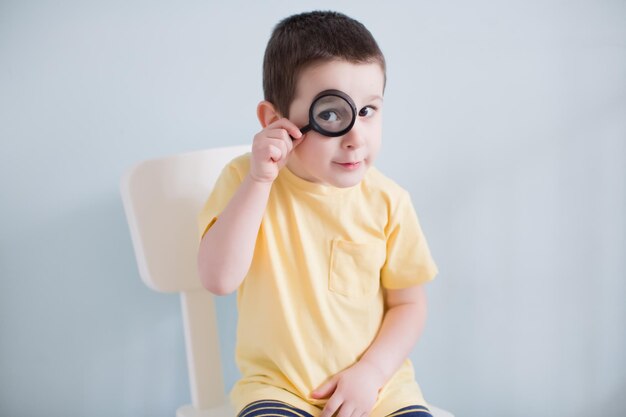 Enfant avec loupe fond bleu