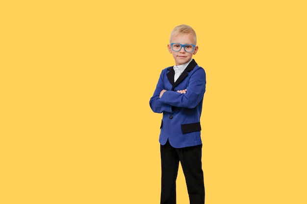 Enfant à lunettes de l'école primaire sur jaune