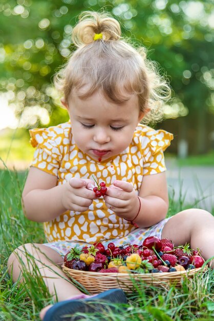 L'enfant mange des baies dans le jardin Mise au point sélective