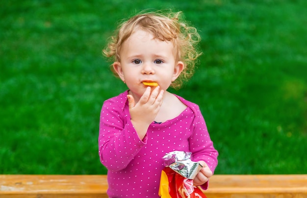 L'enfant mange des chips dans le parc Mise au point sélective